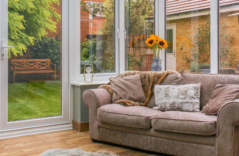 Everest conservatory with a light gray couch and sunflowers