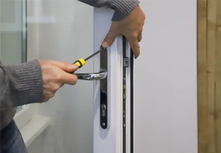 Someone fixing a white Everest door handle with screwdriver