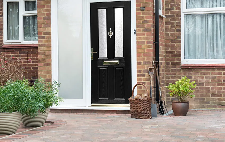 Everest black composite door with white trim on a brick house
