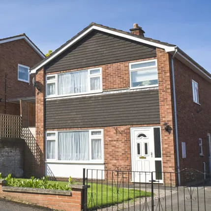 Brick house with dark brown cladding and white windows