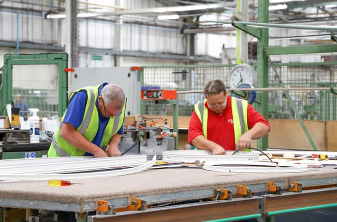 Workers assembling Everest conservatory parts in a factory