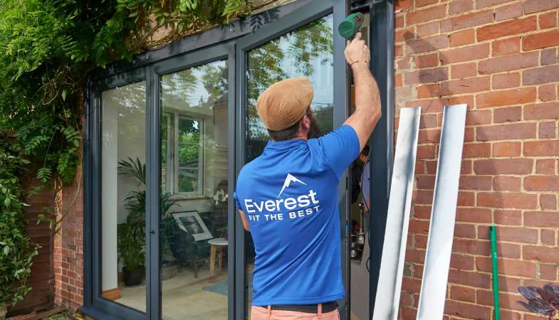 Everest conservatory installer working on a grey conservatory door
