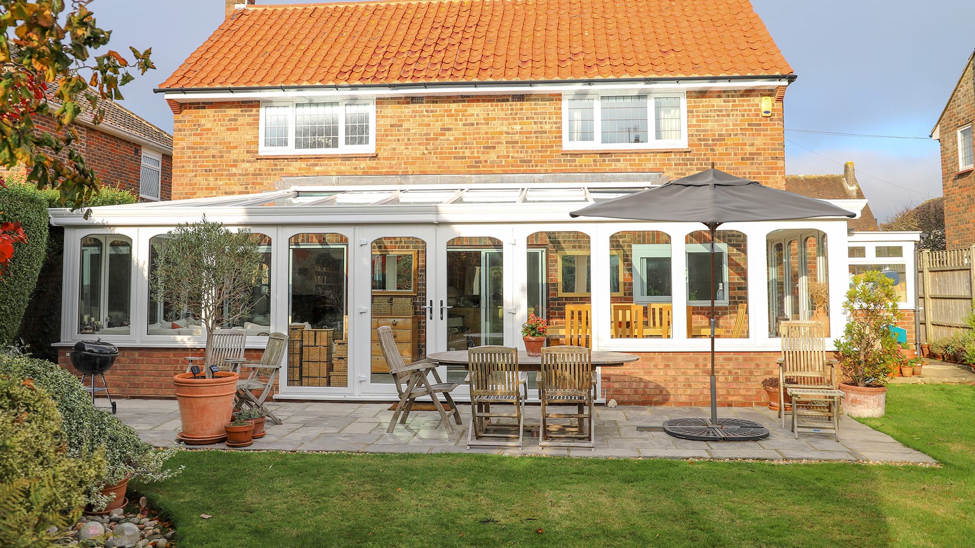 White Everest conservatory with patio furniture and garden