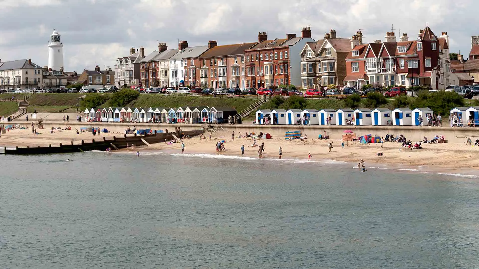 Beach scene with people and colorful beach huts