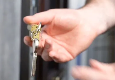 Hand holding keys to a door
