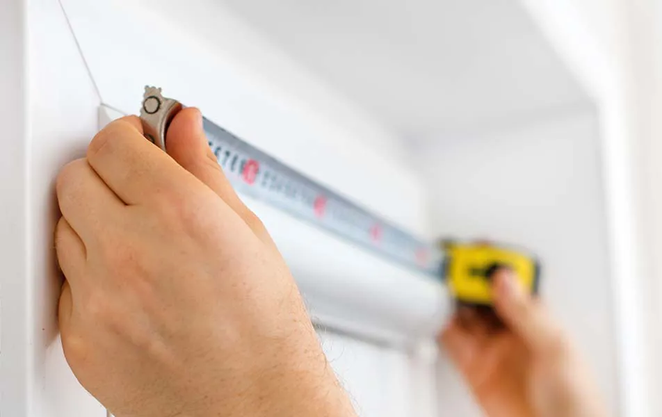 Hands using a measuring tape