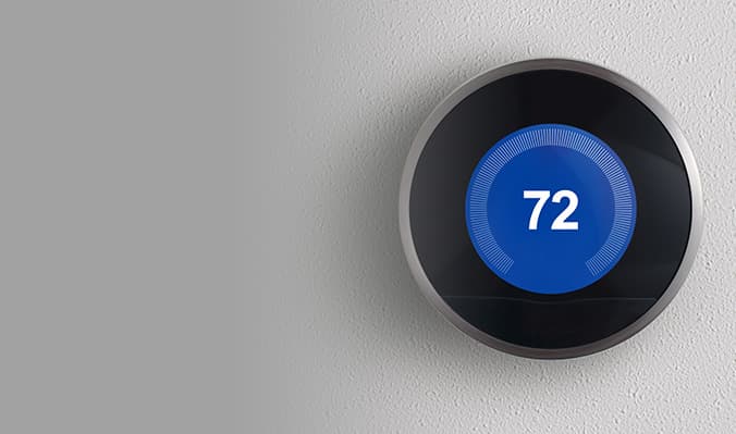 Wall mounted thermostat displaying 72 degrees