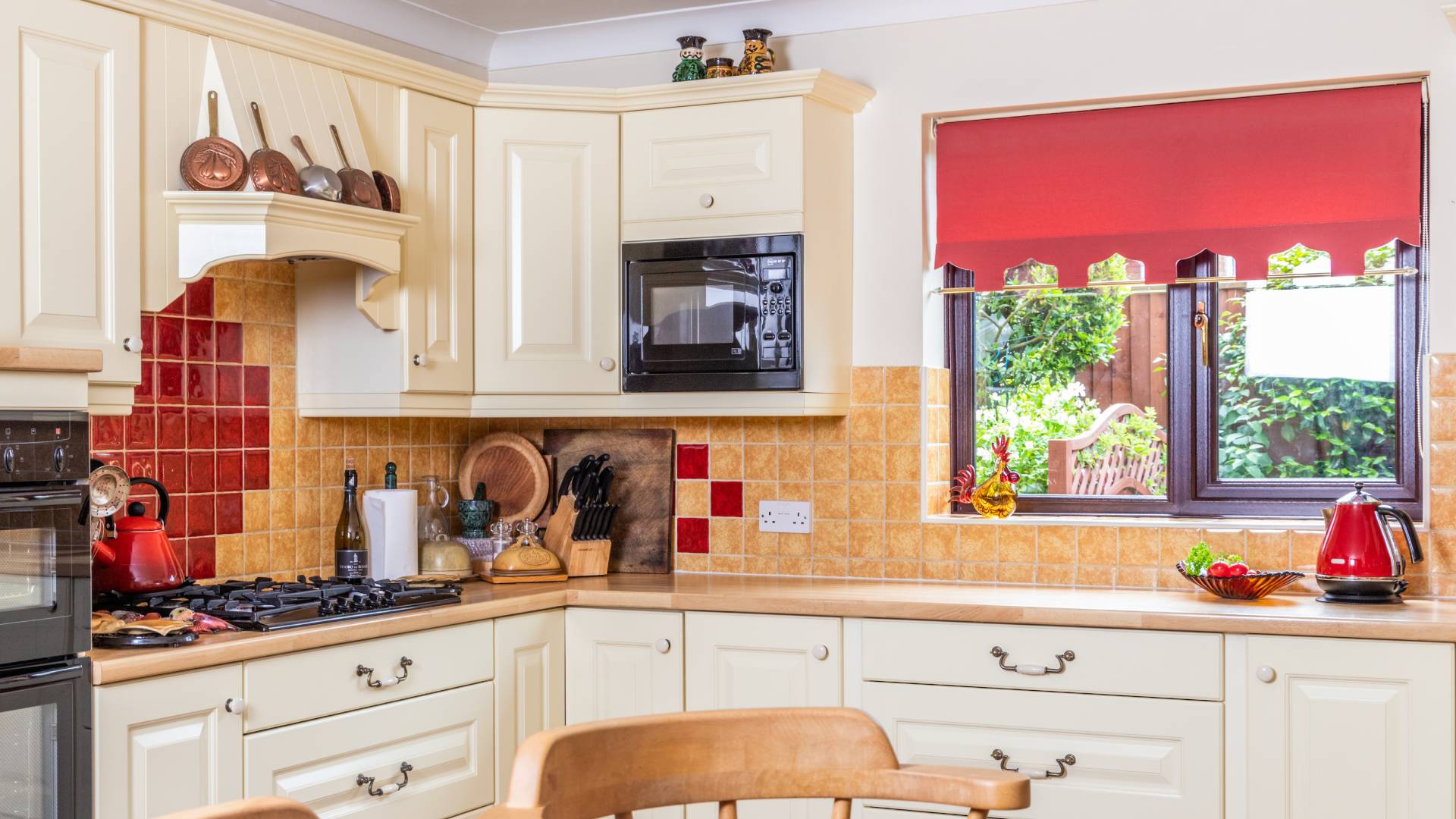 Cream colored kitchen with red and beige tiles