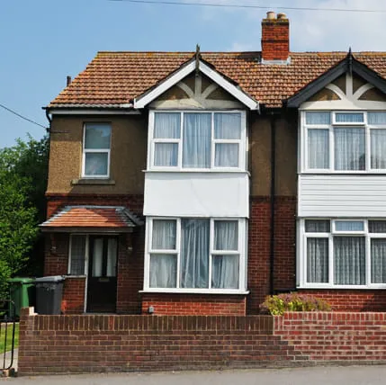 Two storey house with white framed windows and a red brick facade