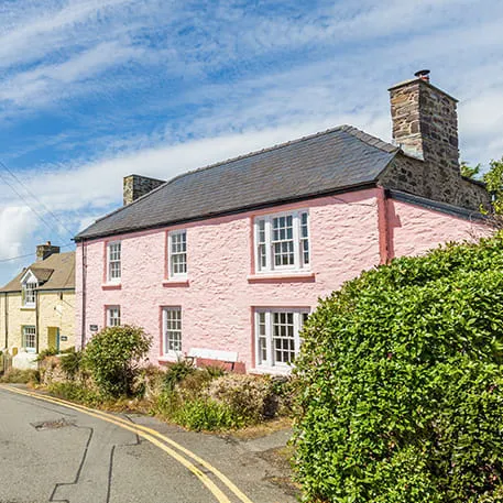 Pink house with white windows on a sunny day