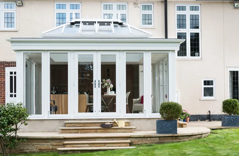 White Everest conservatory with large windows and stone steps
