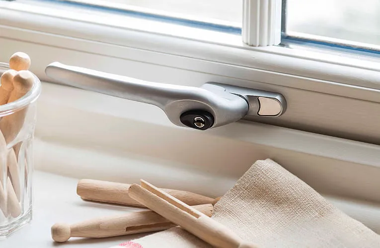 Silver window handle on a white Everest window