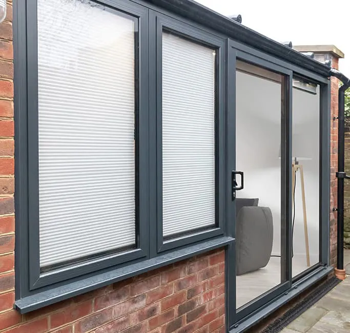 Everest conservatory with dark grey windows and white blinds