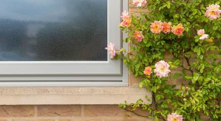 An olive grey uPVC casement window with obscure glass