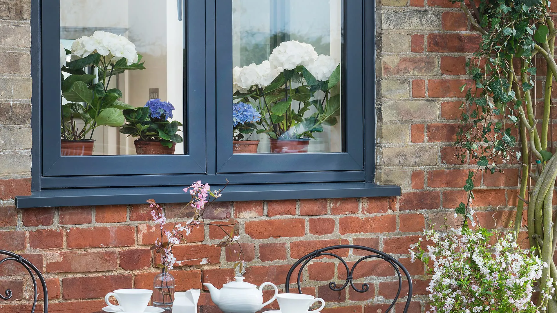 Everest conservatory window with hydrangeas and brick wall