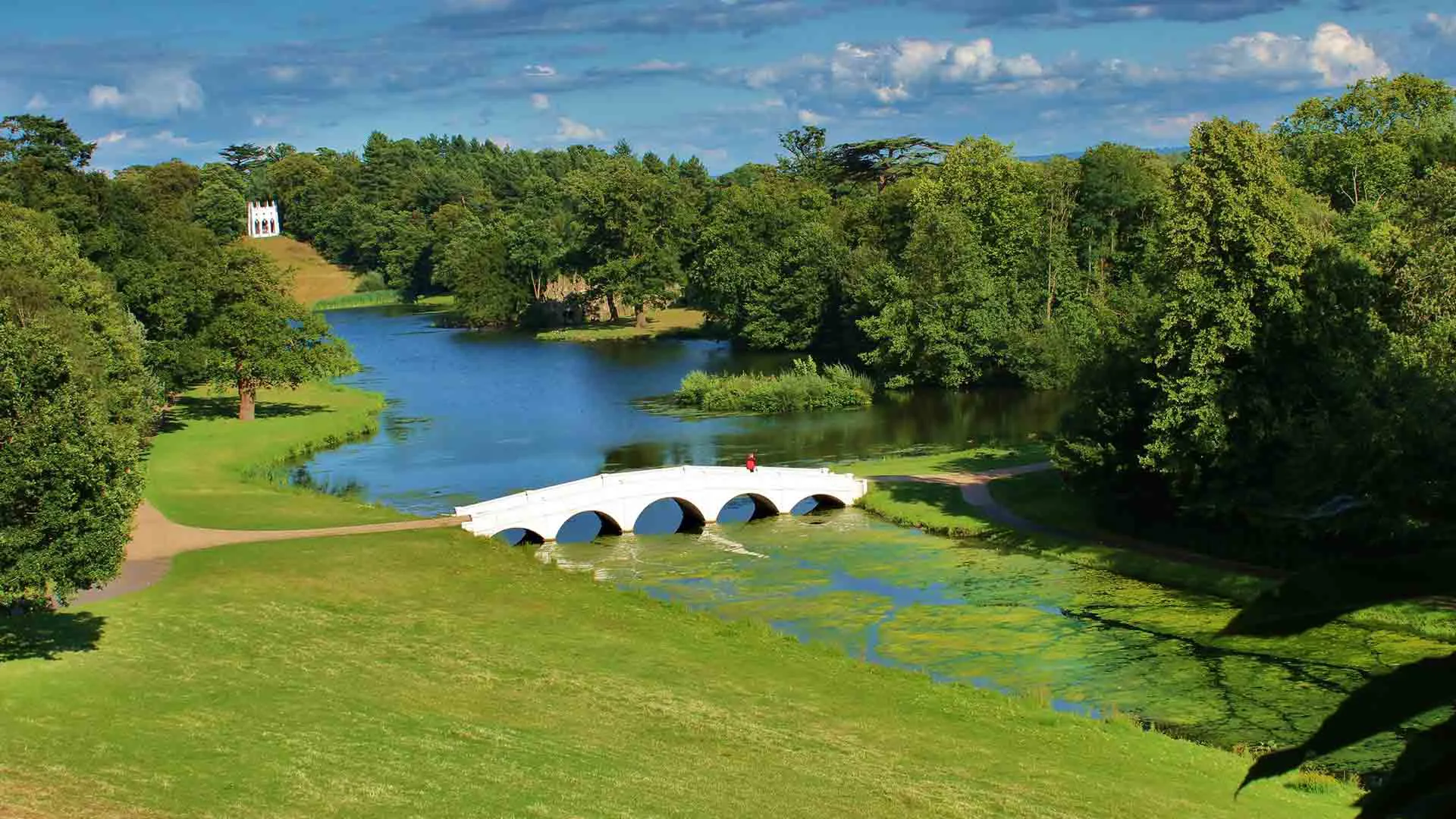 White arched bridge over a lake in a park