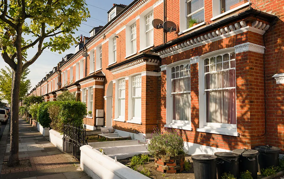 Row of red brick terraced houses with white trim