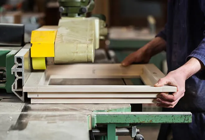 Person working on light wood window frame