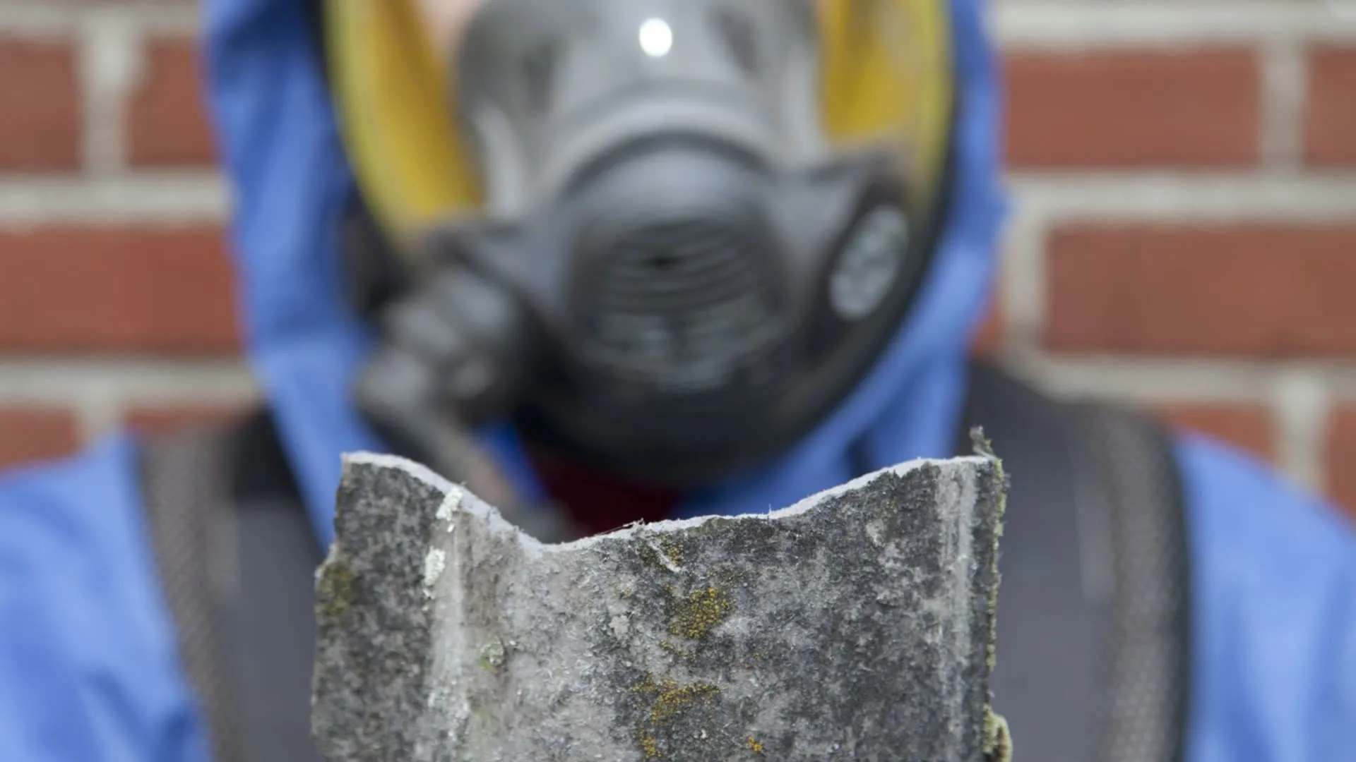 Damaged roof tile being held