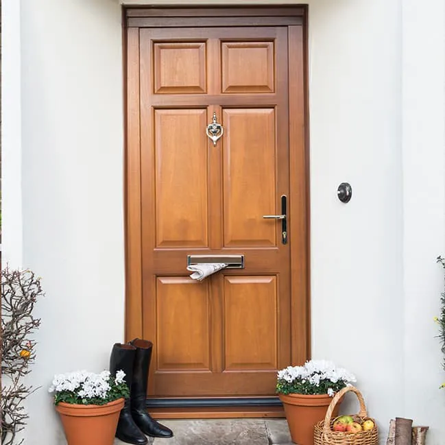 Light brown wooden front door with mail