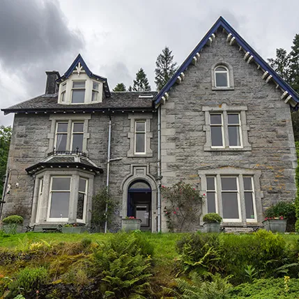 Grey stone building with white trim and dark blue accents