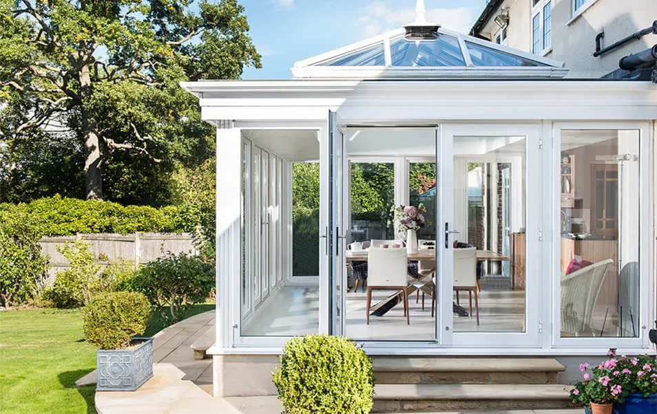 White Everest conservatory with glass roof and bi-fold doors