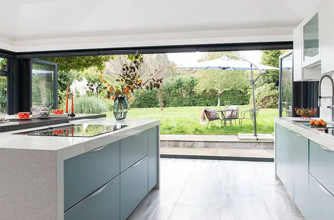 Everest conservatory kitchen with pale teal cabinets and garden view