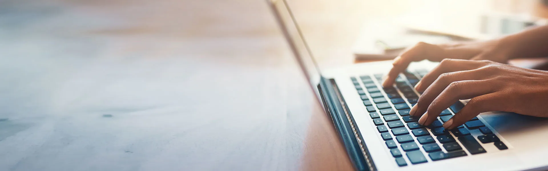 Hands typing on a laptop keyboard