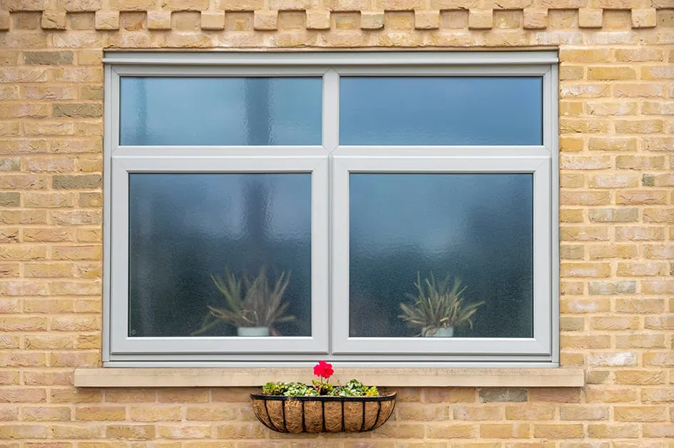 Grey Everest window on a yellow brick wall