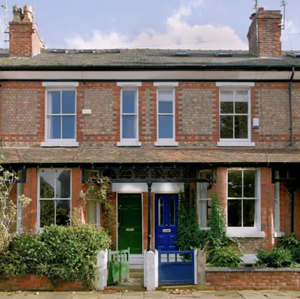 Two storey terraced house with green and blue doors