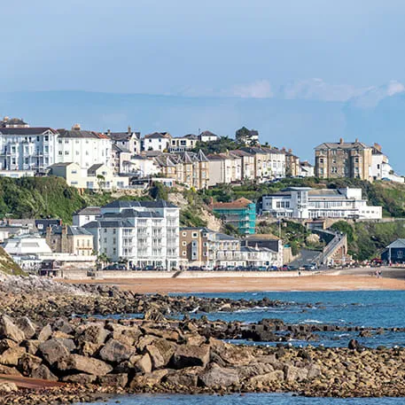 Coastal town with buildings on a hillside and beach