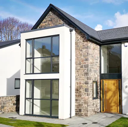 Modern house exterior with large windows and stone facade