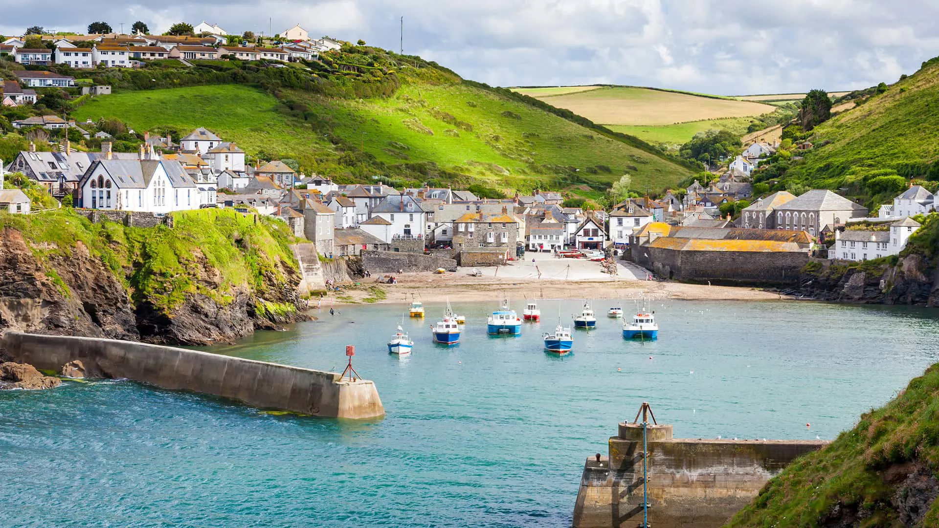 Coastal town with boats in harbor and hills