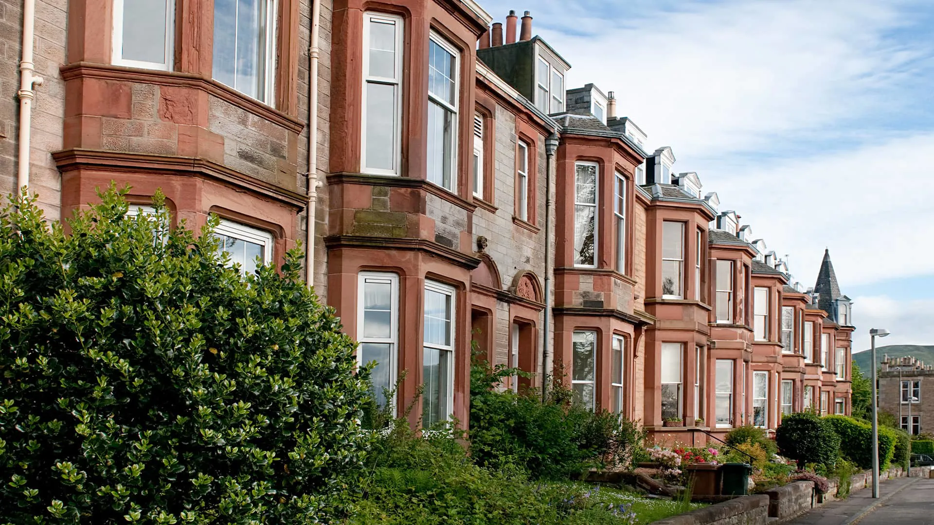 Row of terraced houses with red sandstone and white windows