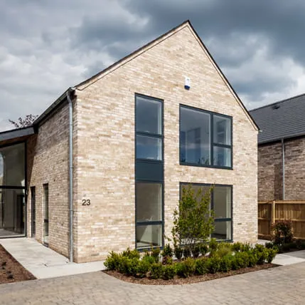Light beige brick house with large windows