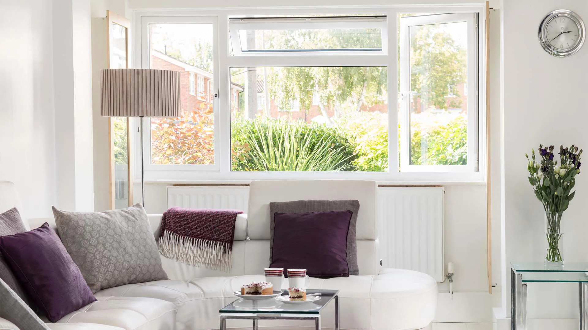 White living room with purple cushions and window view