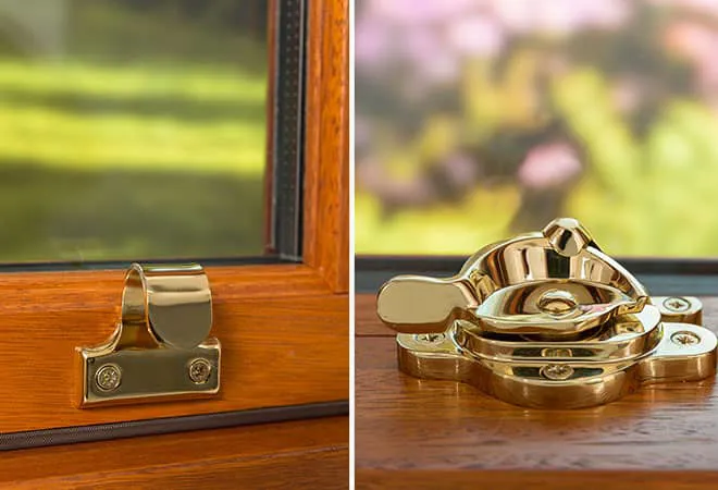 Gold window fasteners on a wooden Everest conservatory window