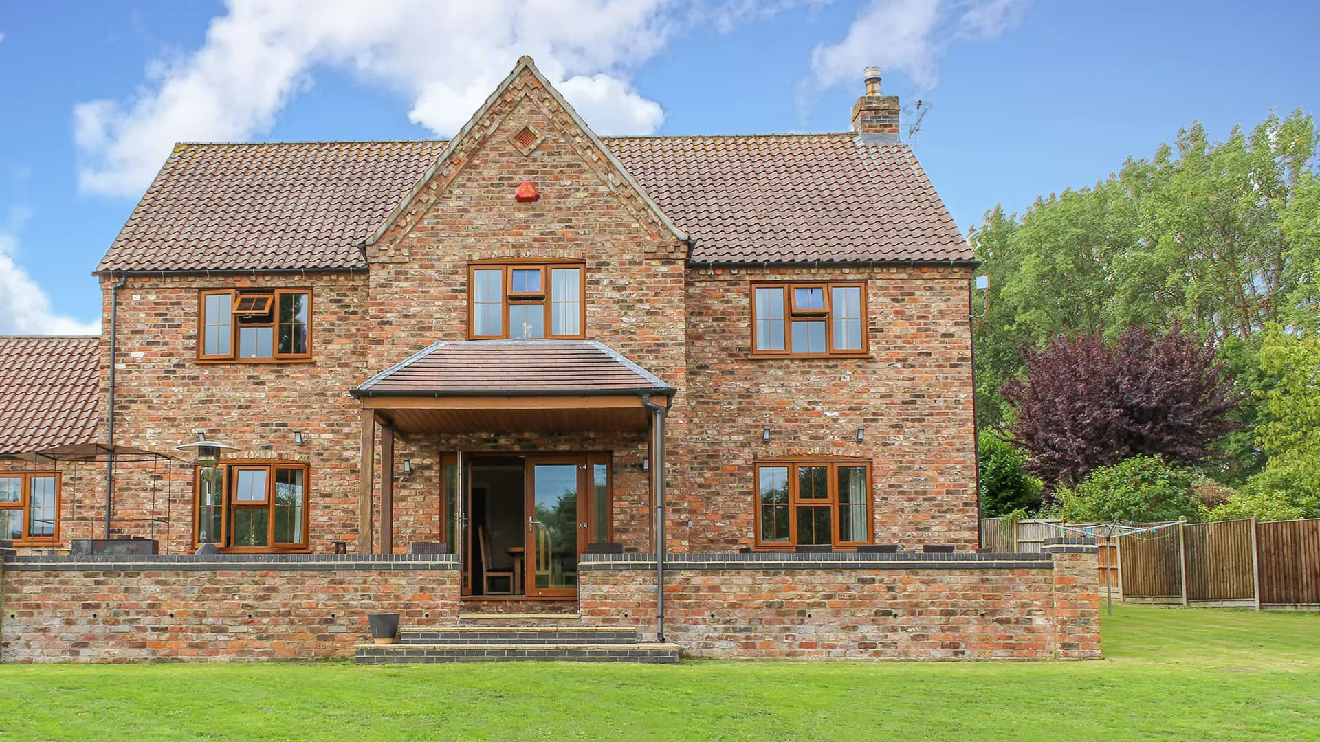 Brick house with brown timber windows and a veranda