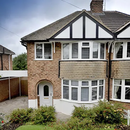 Brick house with white windows and arched doorway