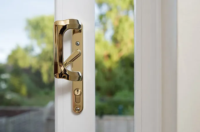 Gold door handle on white Everest conservatory