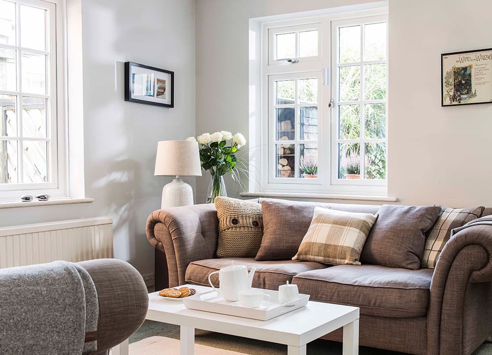 Brown sofa with white coffee table and white windows