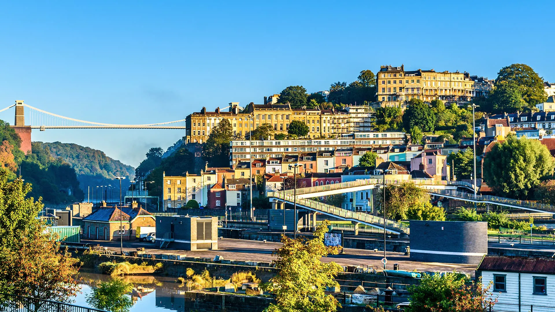 Cityscape with colorful buildings and a suspension bridge