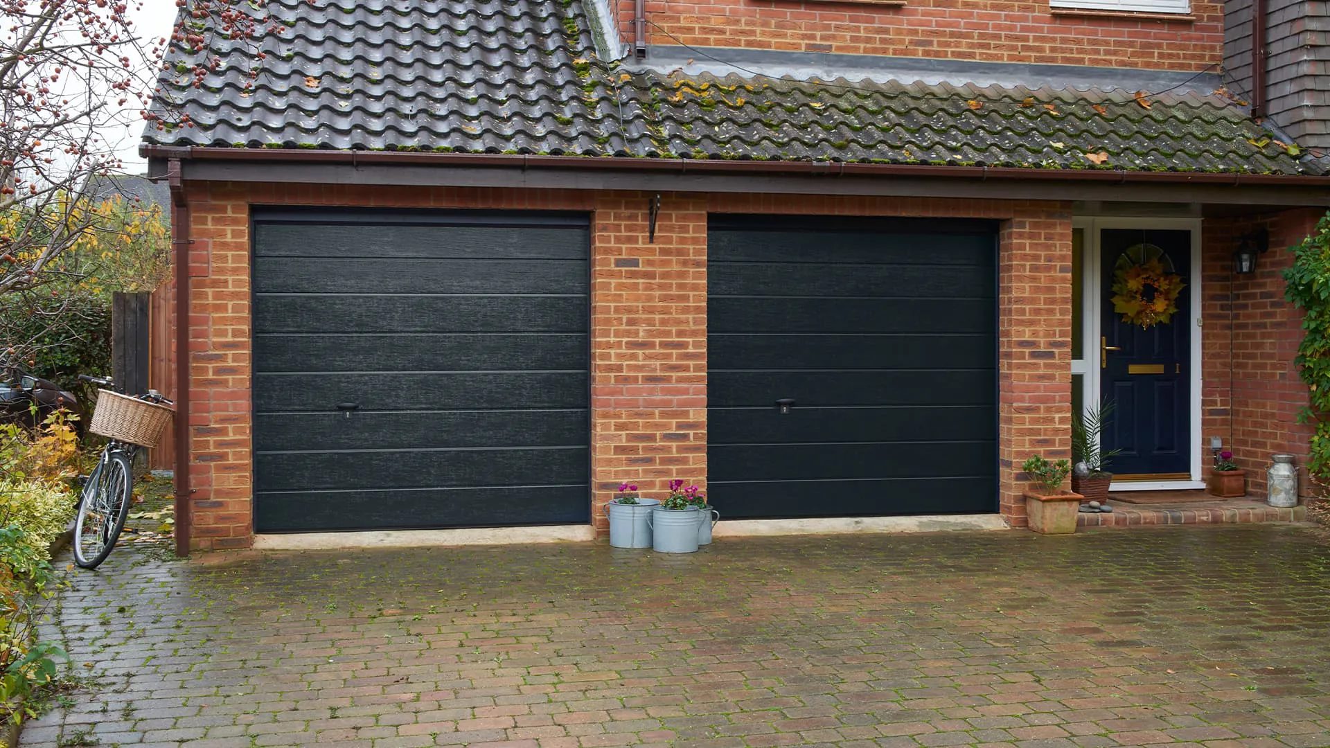 Dark gray garage doors on a brick house