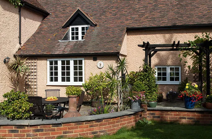 Cream house exterior with white windows and garden patio