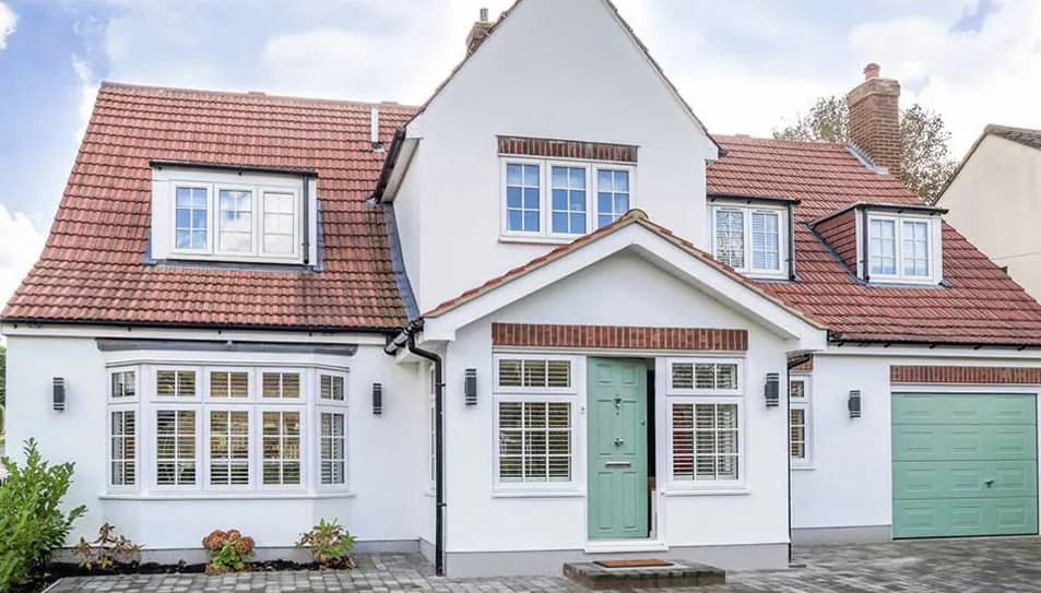 White house with terracotta roof and sage green door