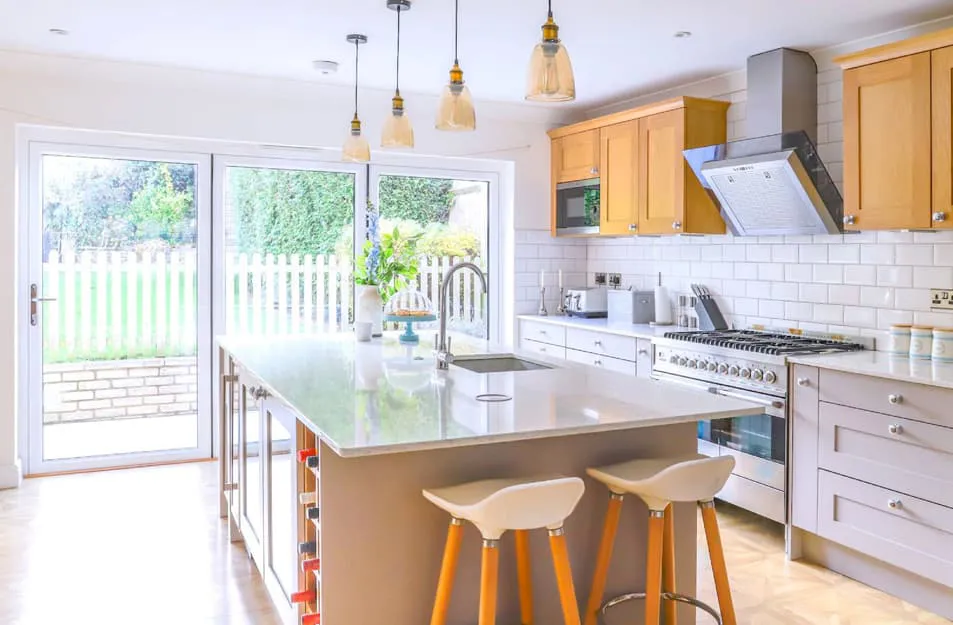 Light kitchen with white tiles, wooden cabinets, and large island