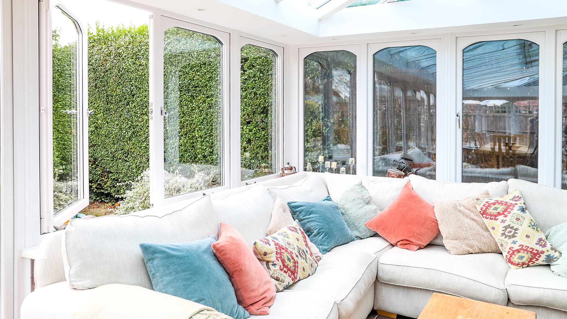 Everest conservatory with white windows and cream sofa with colorful cushions