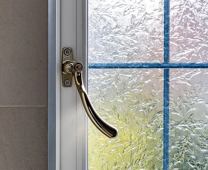 Gold window handle on a white Everest window