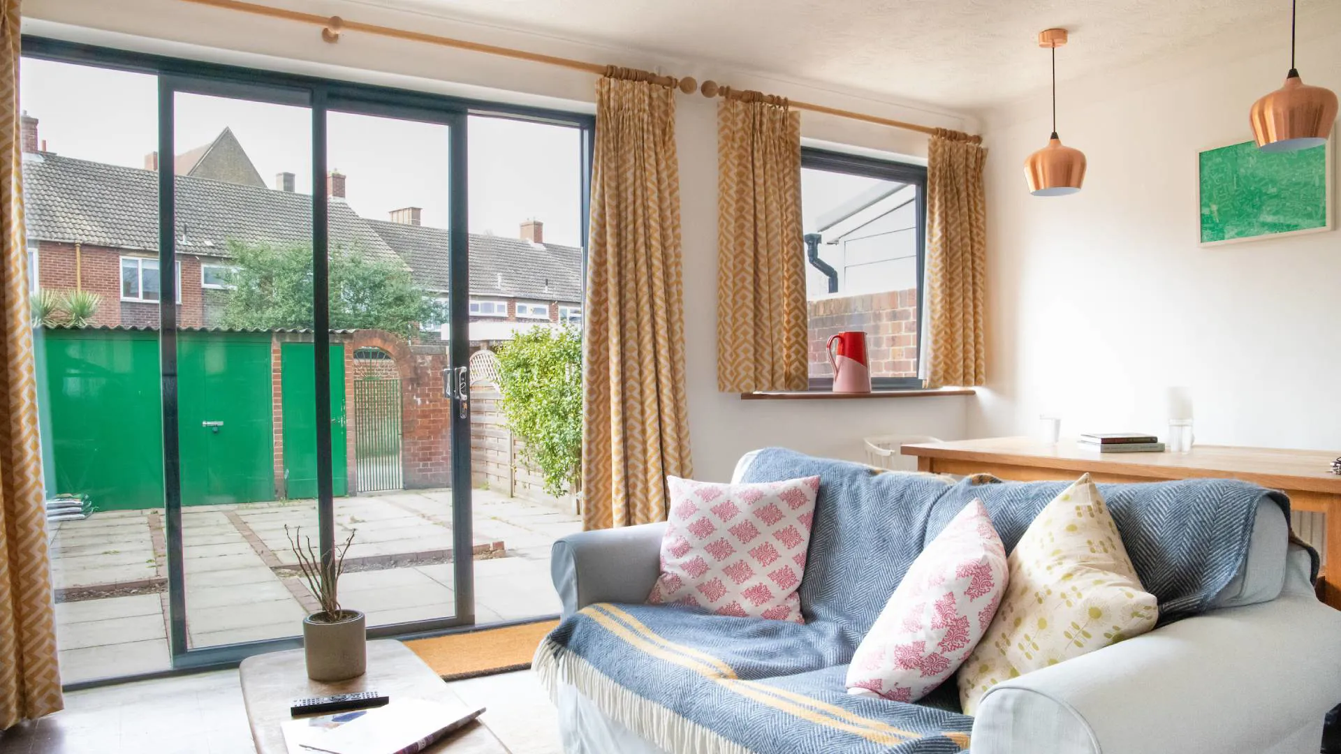 Everest conservatory with light beige sofa, yellow patterned curtains, and green patio doors