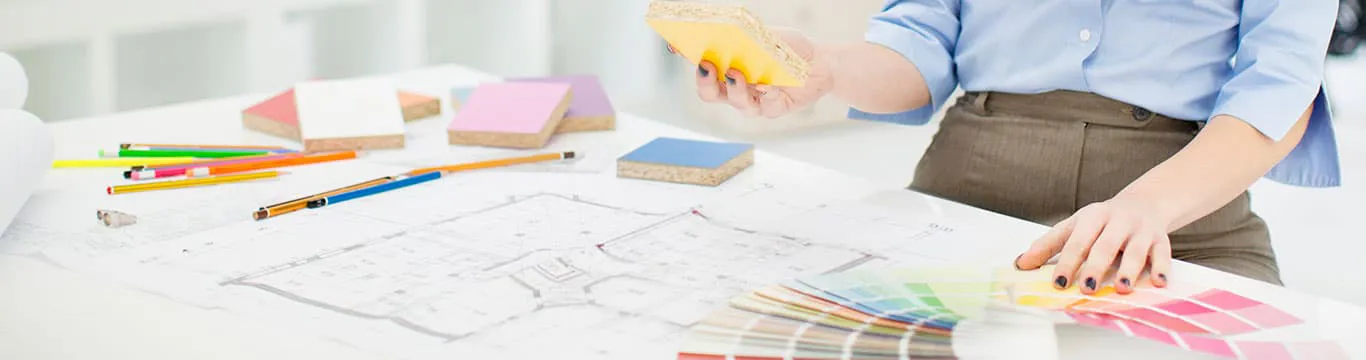 Person reviewing color swatches and blueprints